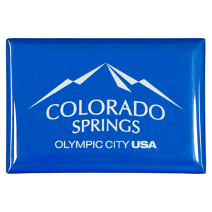 Blue rectangular, shiny magnet with white Colorado Springs: Olympic City USA logo printed onto it