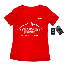 Load image into Gallery viewer, Red short sleeve v-neck t-shirt with white version of the city of Colorado Springs: Olympic City USA logo printed on front. White Nike logo under right shoulder. Team USA and Nike tags attached to right sleeve.
