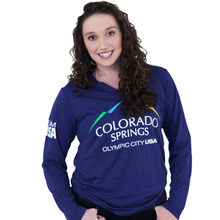 Load image into Gallery viewer, Model wearing dark blue long sleeve v-neck shirt. Shirt has full color logo for the city of Colorado Springs: Olympic City USA printed on front. Team USA printed in white on the left sleeve on the upper arm.

