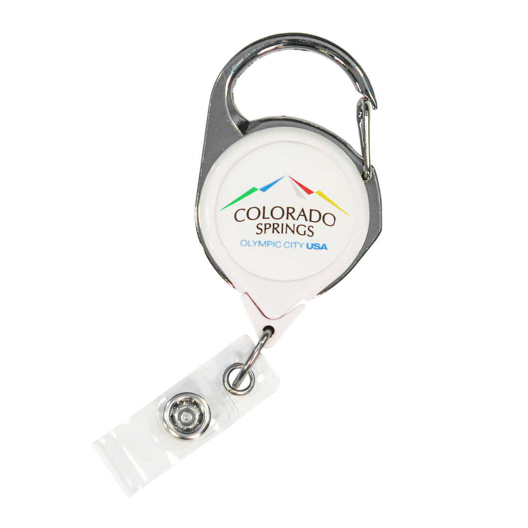 Carabiner badge reel with label that has the full color Colorado Springs: Olympic City USA logo on top of a white background