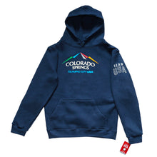 Load image into Gallery viewer, Navy pullover hoodie with hoodie pocket in front. Color version of the city of Colorado Springs: Olympic City USA logo printed in center. Team USA printed in white omn the upper right sleeve. Team USA tag attached to bottom of same sleeve.
